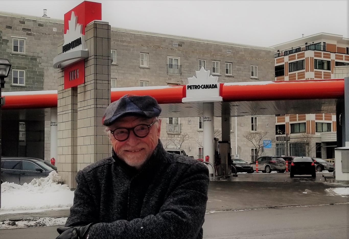 Man smiling outside Petro-Canada gas station in winter.