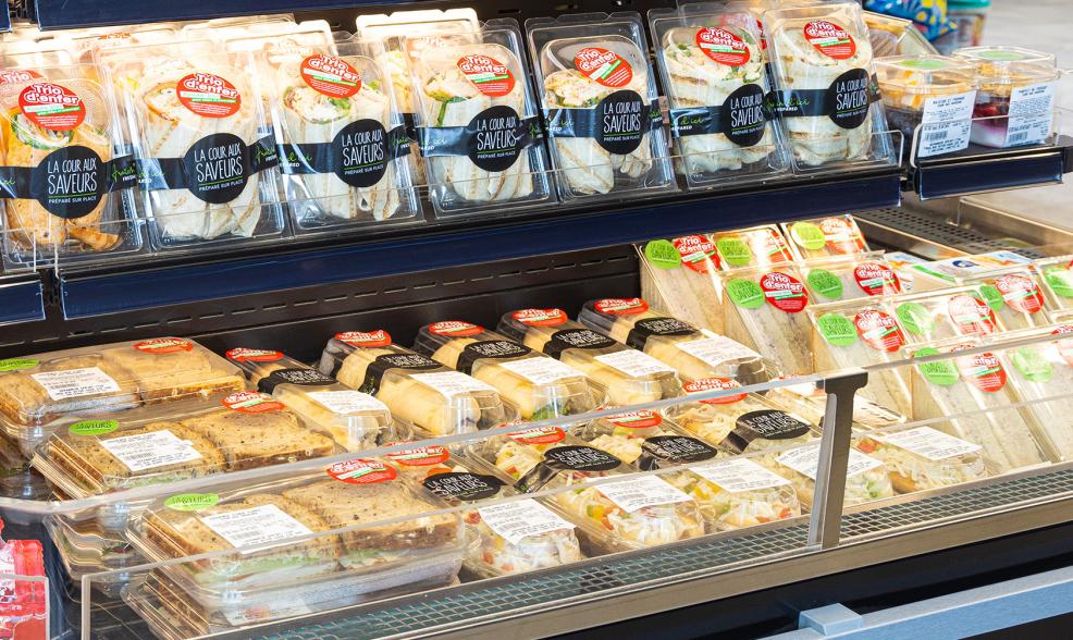 Variety of packaged sandwiches in display fridge.