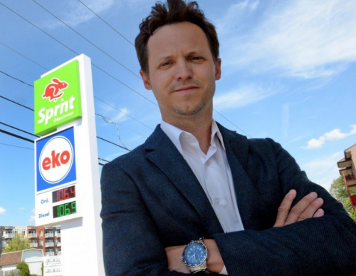 Man in front of gas station signage.