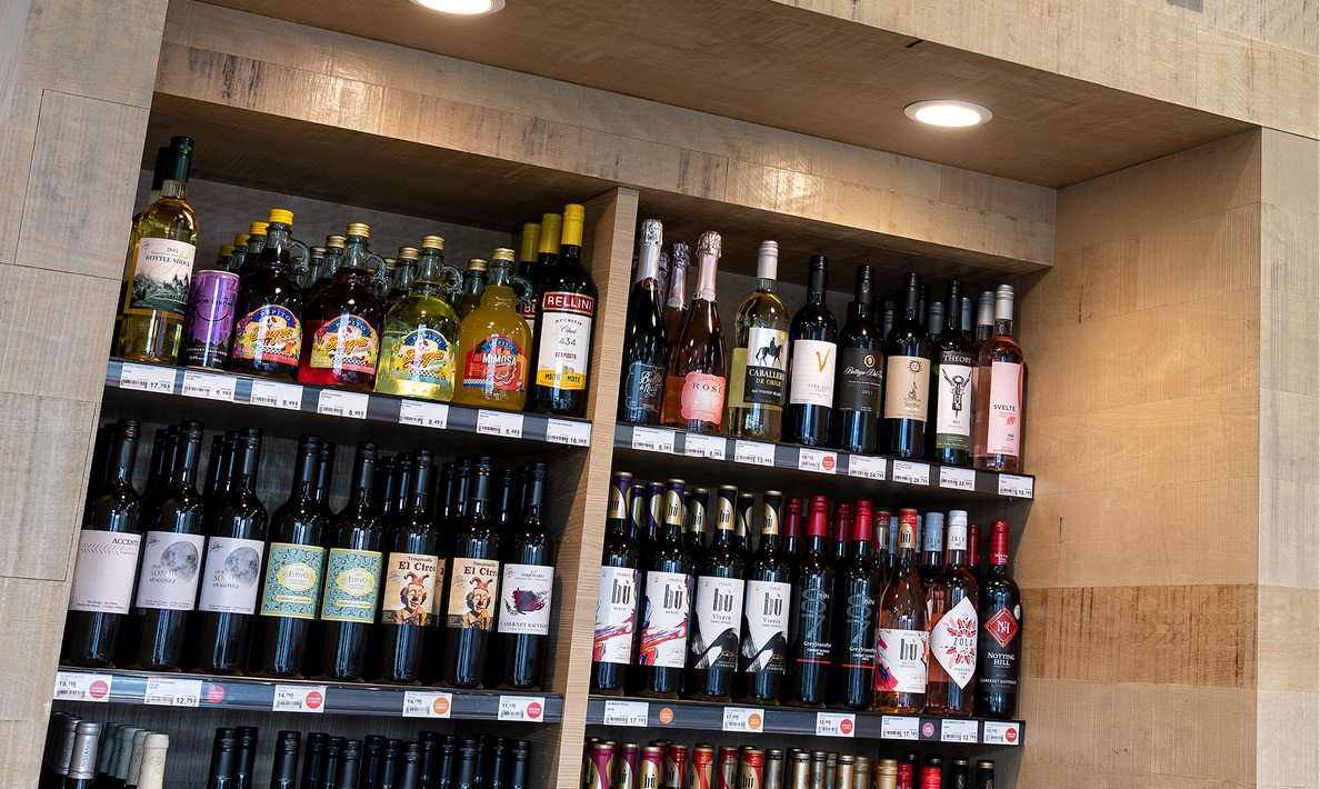 Assorted wine bottles on wooden shelves.