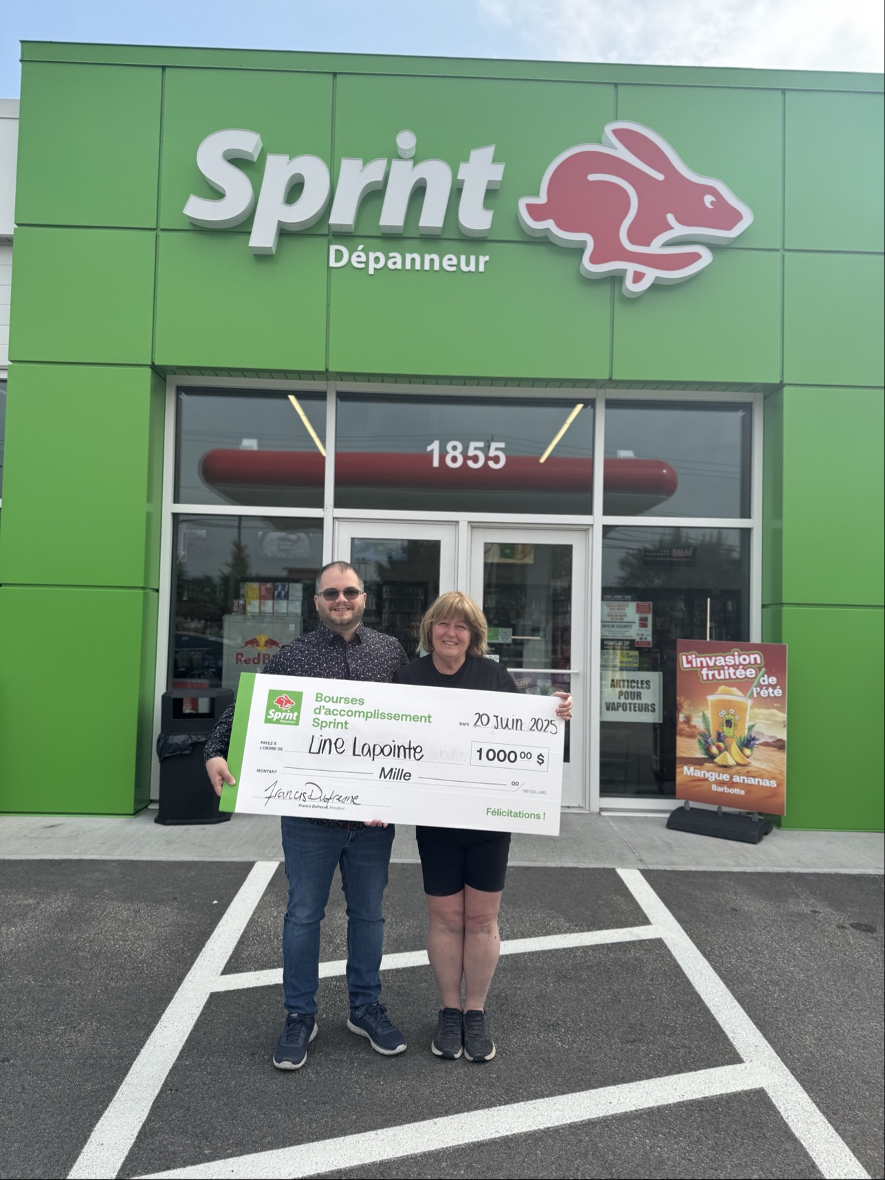 Des personnes avec un chèque devant Dépanneur Sprint.