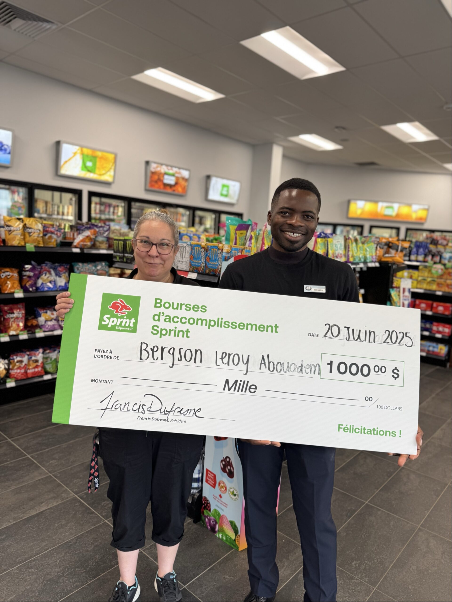 Deux personnes avec chèque géant dans un magasin.